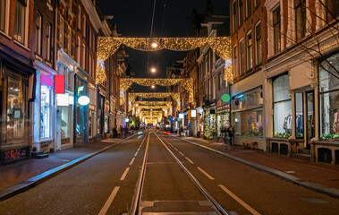 Fototapeta na wymiar Decorated street in Amsterdam at christmas time in the Netherlands by night