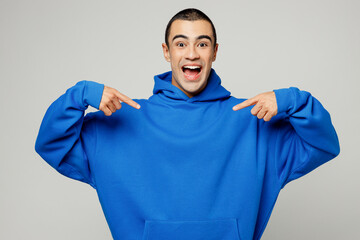 Young overjoyed excited happy fun winner middle eastern man he wear blue hoody casual clothes point...