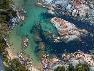 Naklejka na ściany i meble Aerial shot of a beautiful coast with turquoise waters and rocks