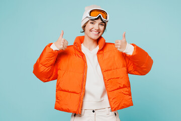 Skier young woman wearing warm padded windbreaker jacket hat ski goggles mask look camera show...