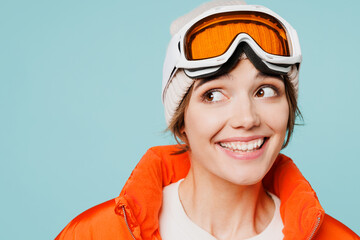 Close up skier young happy woman wears warm padded windbreaker jacket hat ski goggles mask look...