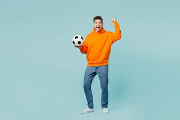 Full body young man fan in orange hoody casual clothes cheer up support football sport team hold...