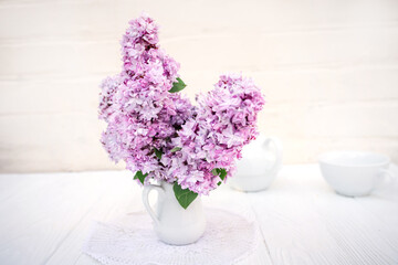 Creative still life. Delicate bouquet of lilacs in a vase. Spring concept