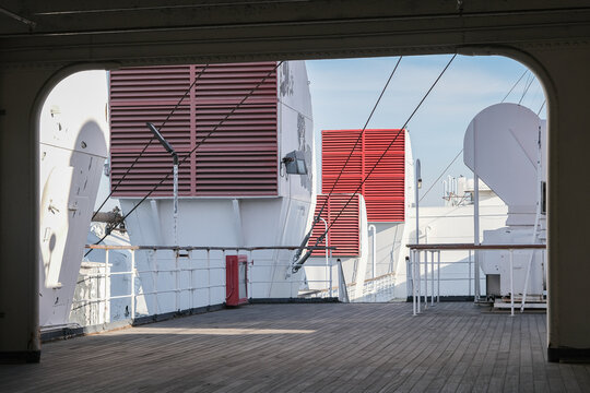 Outdoor promenade and sun decks of nostalgic luxury cruiseship cruise ship ocean liner with sun loungers and deck chairs on open terrace with superstructure and mast details