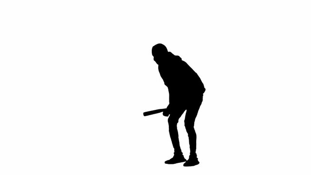 Black silhouette of thief on isolated white background. A male robber in hoodie and balaclava walks with a wooden club in his hands, preparing to commit a crime. Half-turn.