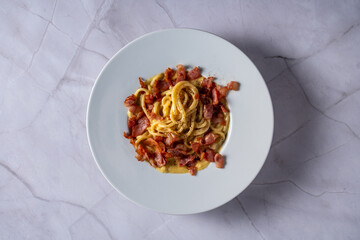 top view plate with pasta carbonara on marble top