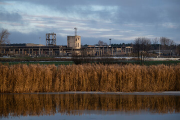 Fototapeta na wymiar old abandoned industrial building on riverside. Early winter landscape 