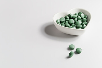 green spirulina detox pills on white table