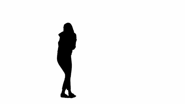 Black silhouette of a woman on a white isolated background. A young girl walks, looking around frightened, fleeing faster from danger. Side view.