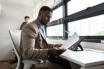 African businessman working with paper work and team business at office	