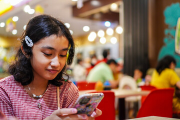 Close-up photo of a girl playing mobile games on his phone with copy space for text