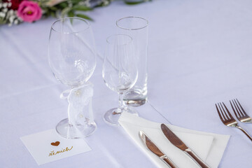 Wedding table with detail of glasses, cutlery and signs with name tags in the Czech language