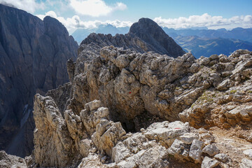 At the summit of steep mountain peak on a sunny day: View to the summit of Sassopiatto Plattkofel peak in the dolomites, South Tyrol, Italy