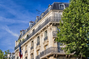 paris, frankreich - typisches pariser gebäude mit nationalflagge