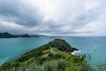 A wide-angle photo of Pigeon Island and Rodney Bay in St Lucia with a dramatic overcast sky above. 