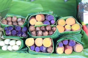 Group of waternut, chinese water chestnut, purple and yeloow sweet potato in banana leaf plate in the fresh market.