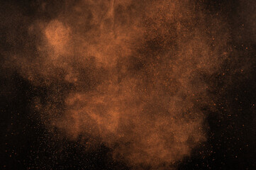 Orange powder explosion on black background. Flame cloud. Yellow dust explode.