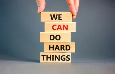 Foto op Canvas We can do hard things symbol. Concept words We can do hard things on wooden blocks. Beautiful grey table grey background. Businessman hand. Business, we can do hard things concept. Copy space. © Dzmitry
