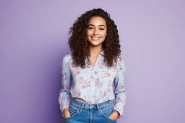 Obraz premium Portrait of a young lady smiling in abstract flower pattern top and blue jeans and looking into camera