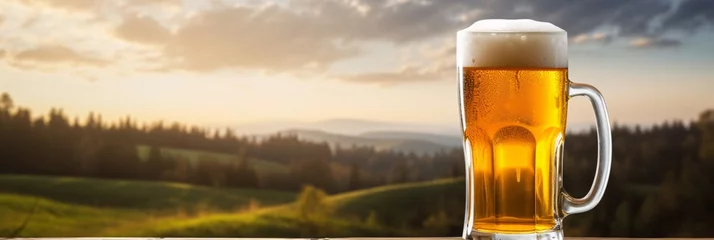 Foto op Plexiglas Irish beer in mug on the table on the background of evening Ireland landscape with forest and meadow. Copy space for text. St Patrick's Day celebration. Banner, header with copy space © dreamdes