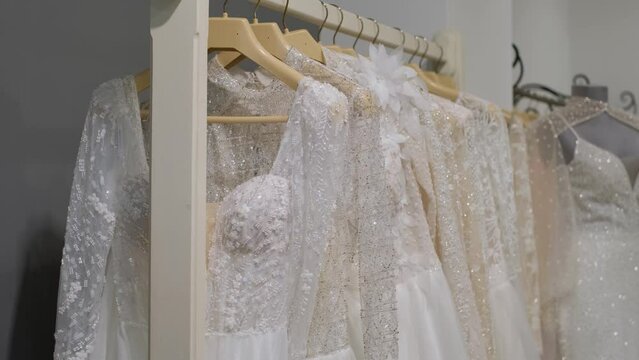 Various wedding dresses in the sales area of a specialized boutique, close-up