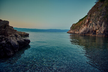 beautiful sunset over the sea with rocks and boat in the foreground
