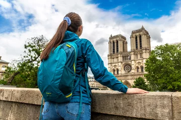 Foto auf Acrylglas Woman traveler at Notre Dame de Paris is the one of the most famous symbols of Paris, France © Sergii Figurnyi