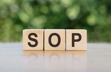 SOP - acronym from wooden blocks with letters, abbreviation SOP standard operating procedure concept, blur background