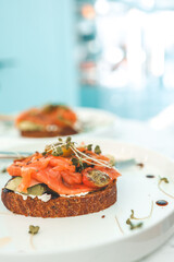 Healthy breakfast. Avocado toasts with salmon and poached eggs on ceramic plate