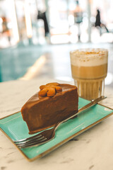 Chocolate cake and a cup of latte in a cozy coffee shop