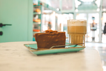 Chocolate cake and a cup of latte in a cozy coffee shop