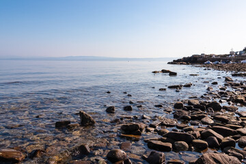 Panoramic view of idyllic coastline of Gulf of Piran, Adriatic Mediterranean Sea, Slovenia, Europe. Summer seaside vacation. Stroll along the tranquil stone beach of Fiesa. Shoreline Slovenian Istria