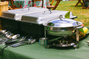 Outdoor kitchen equipment. Preparing food on a barbecue party. Food tray with kitchen utensils,...