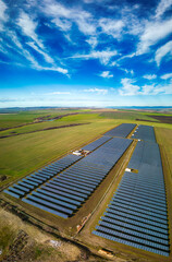 Solar panel produces green, environmentaly friendly energy from the setting sun. Aerial view from drone. Landscape picture of a solar plant that is located inside a valley
