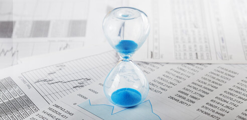 Best time for investment. Hourglass, financial charts and calculator.