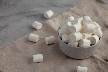 Fototapeta na wymiar White Marshmallows in a Bowl, side view. Copy space.