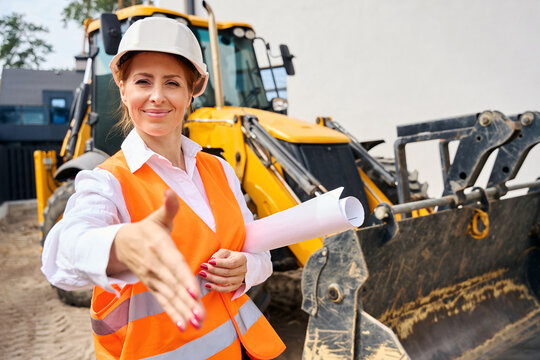 Friendly building inspector greeting someone on development site in morning