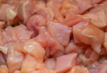 Chopped raw chicken fillet for background use. A slide of sliced raw boneless chicken breasts in close-up, background, texture.
