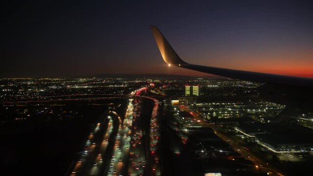 Jet plane prepare to landing in Los Angeles LAX airport. Porthole view with wing