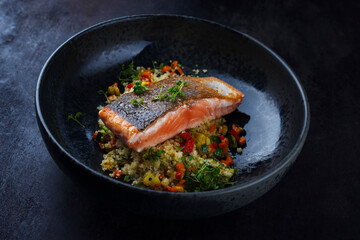 Traditional Mediterranean salmon fish fillet with vegetable cuscus served as close-up on a design...
