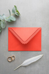 Wedding background, red invitation envelope on gray background, top view
