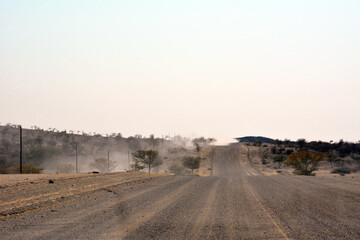 A deserted stony road in the hot desert foothills under a bright blue sky