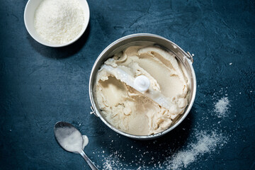 Top view of vegan coconut ice cream in bucket on blue background © Katecat
