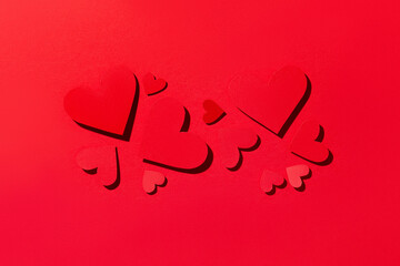 Red paper hearts on a red background. Love concept. Valentine's Day. Top view.