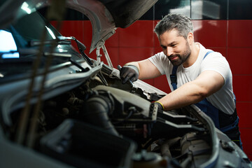 Fototapeta na wymiar Professional car service technician is fixing his customer automobile
