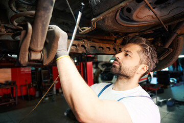 Professional automotive service technician is doing car inspection