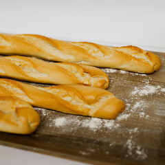 Barras de pan sobre una mesa de madera con harina 