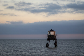 Lighthouse in the sea at sunset, Dovercourt low lighthouse at high tide built in 1863 and discontinued in 1917 and restored in 1980 the 8 meter lighthouse is still a iconic sight
