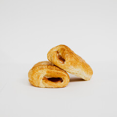 Dos napolitanas de jamón y queso sobre fondo blanco. Fotografía de producto de panadería. 