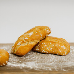 Hogazas de pan sobre mesa de madera y fondo blanco. fotografía de producto 